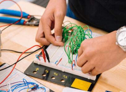 A person testing wires on a electronic device