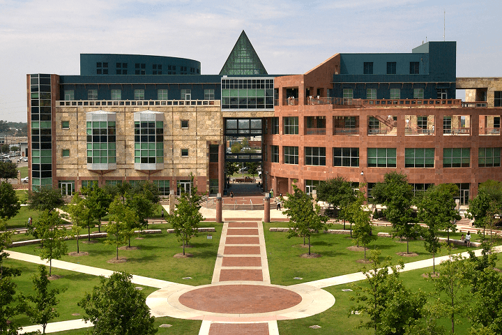 Five-story academic building at the Downtown campus with grass, trees and paths in front.