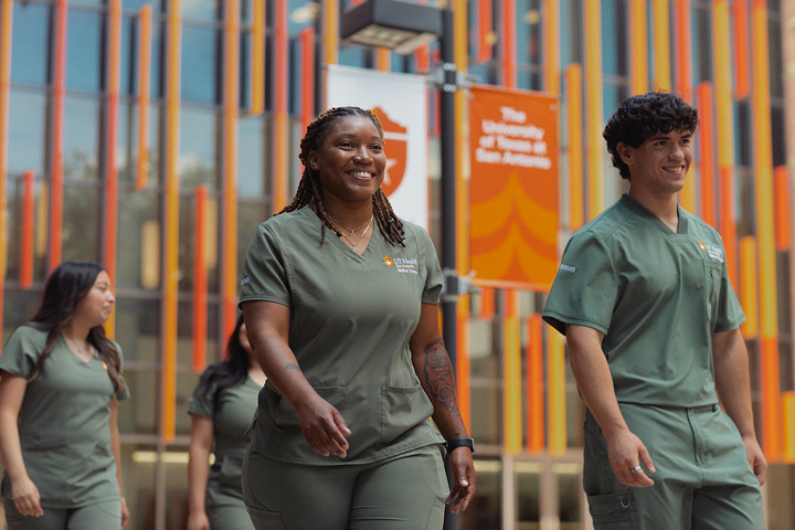 UT Health students wearing green scrubs walking through campus