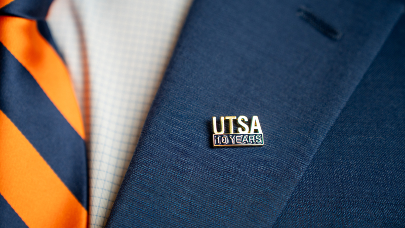 Closeup shot of a lapel with a pin that reads 'UTSA 10 Years'