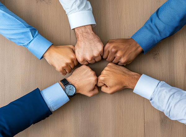 team members with fist together in a circle